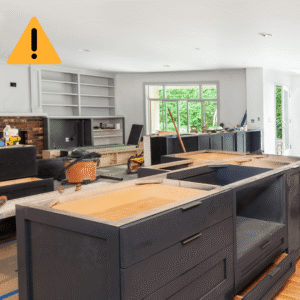 A kitchen renovation in progress with an unfinished island and a caution warning icon overlay.